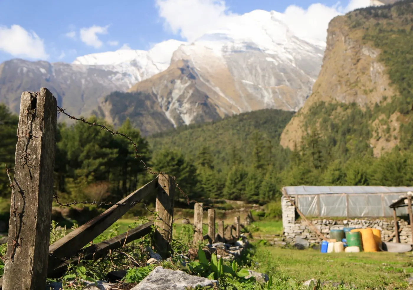 A wooden fence and a homestay below a snow peak